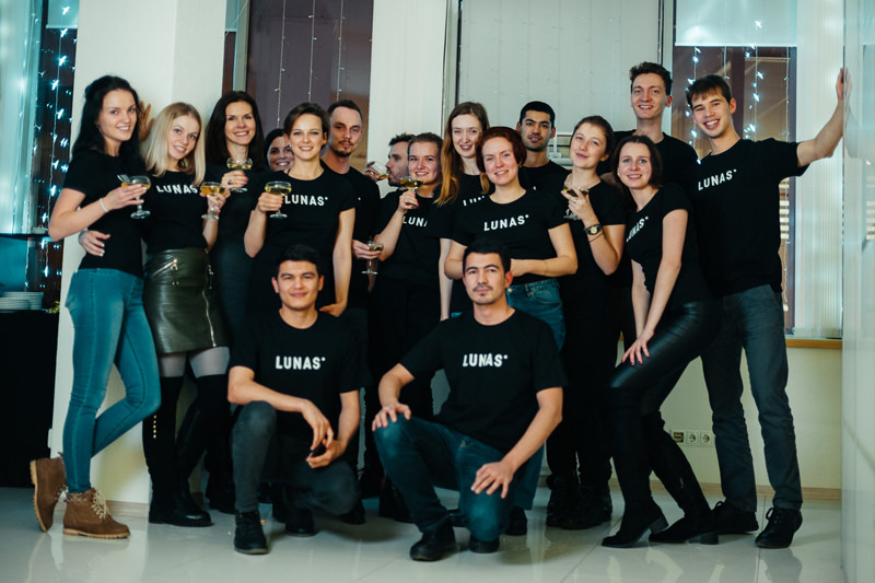 A cheerful team of 3D artists, project managers and chief officers in special Lunas T-shirts during corporate New year celebrations