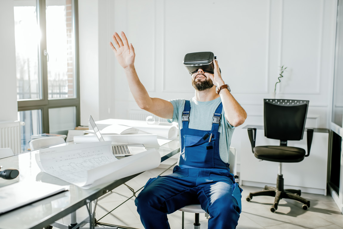 Construction foreman in blue working uniform makes advantage of virtual reality gear to imagine projected environment