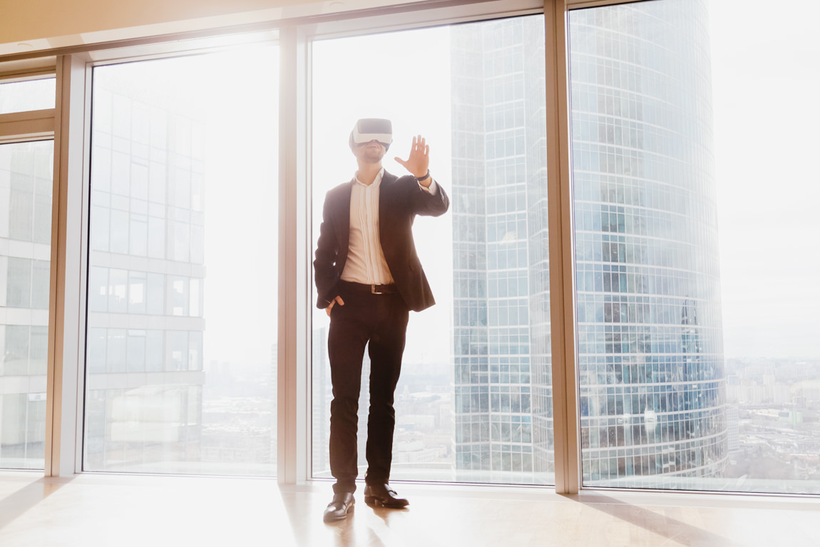 Man with VR goggles looks around office space viewing walkaround 3D tour