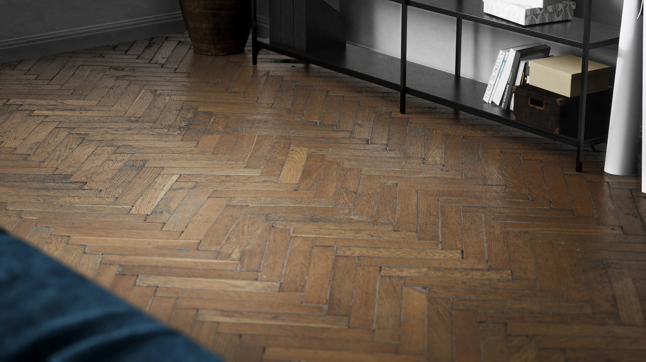 A detailed 3D rendered close-up of the herringbone parquet floor with the shabby chic effect of photorealistic quality