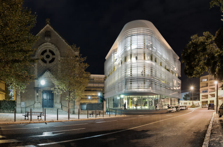 Nighttime 3D architectural rendering of a business centre in Beziers, France incorporated into a photo of existing surroundings