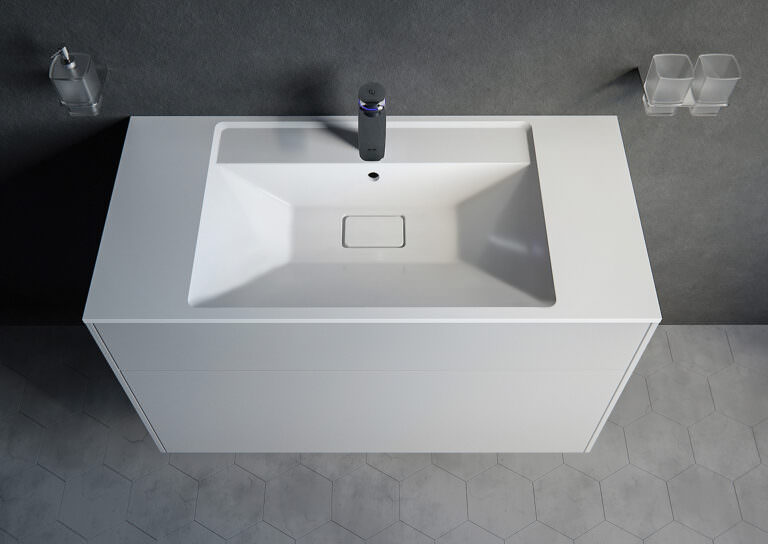 Product visualization from up above of the bathroom sink with a tap standing on a gray ceramic floor made of hexagonal tiles against a background of rough stucco wall