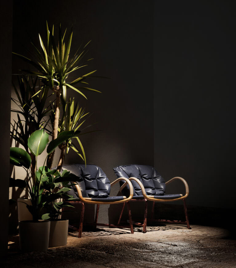 Product rendering of two chairs with leather pillows and bamboo base standing in the corner near flowerpots with ceiling spotlights