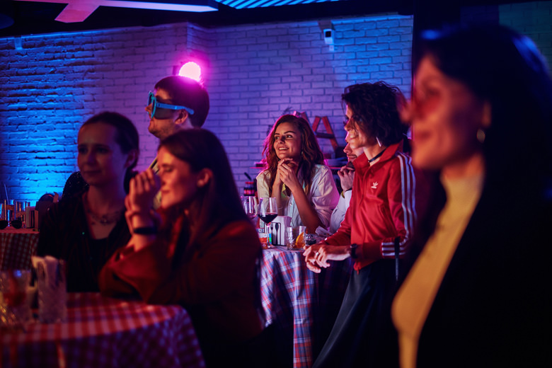Party ambience with deam light and guys at the tables drinking and listening to music